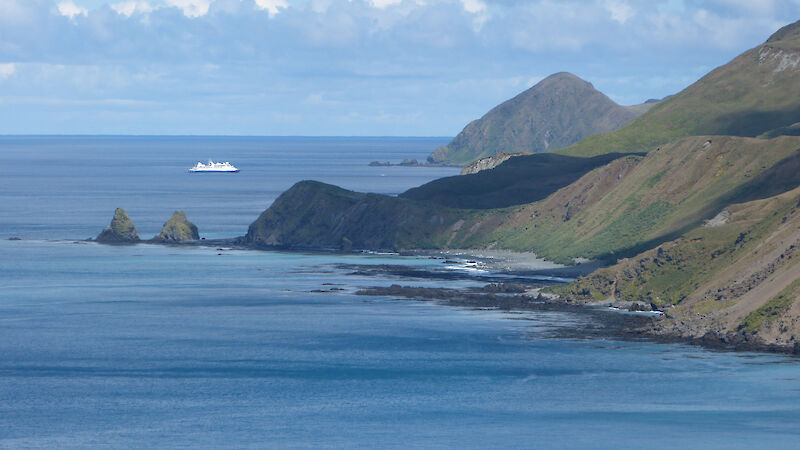 View along the east coast with tourist ship in distance on clear day