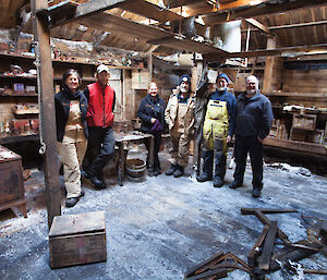 Expeditioners pose inside Mawson's Hut