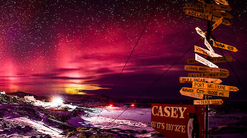 Panorama of the Aurora Australis in the red spectrum over Casey station on clear starry night