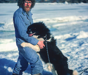 Tom Maggs outside in the snow with a husky