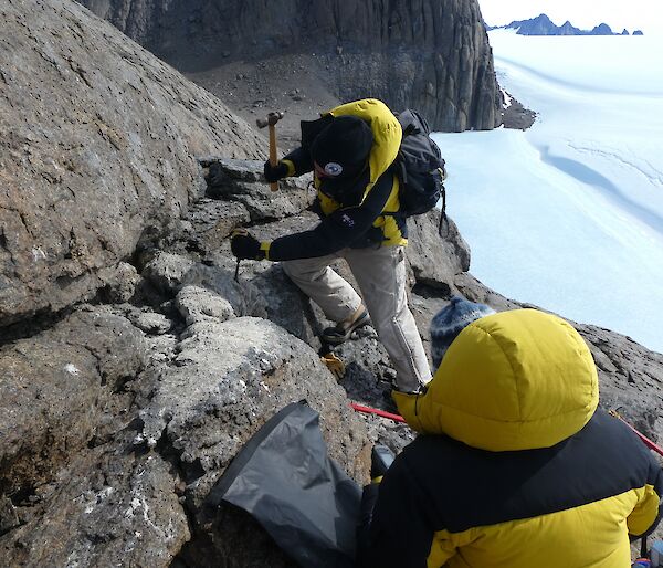 Marcus Salton chisels a thick sample of very hard mumijo off rocks outside a nest cavity in the Masson Range near Mawson research station.