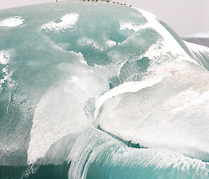 A large iceberg with penguins on top