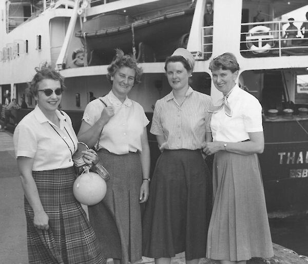 Four women standing at the stern of a ship