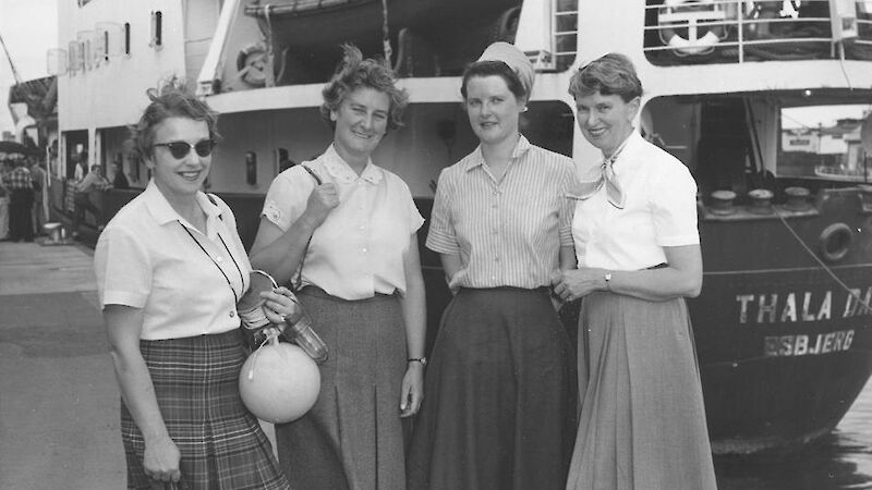 Four women standing at the stern of a ship