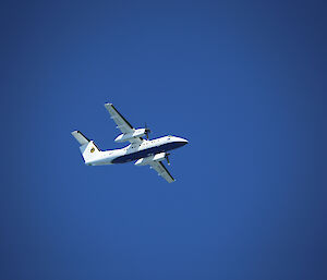 A Dash 8 aircraft against blue sky.