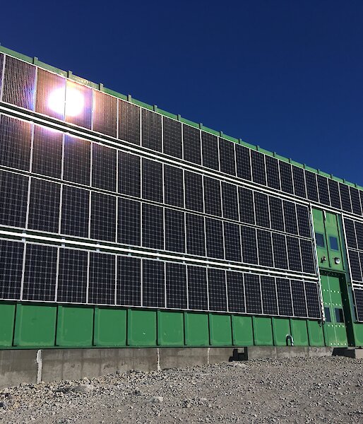 The 105 solar panel array installed, with a wind deflector visible down the length of the array on the left side of the building, to minimise the effects of high wind speeds during blizzards.