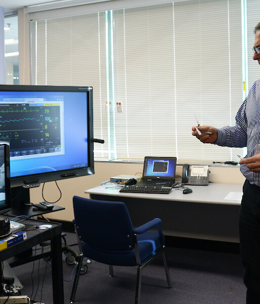Chief Medical Officer, Dr Jeff Ayton, and another doctor viewing an Antarctic medical procedure remotely via a telemedicine monitor