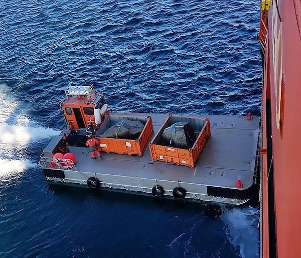 Boulders being loaded from a barge onto Aurora Australis