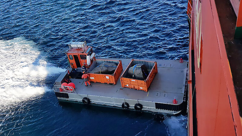 Boulders being loaded from a barge onto Aurora Australis