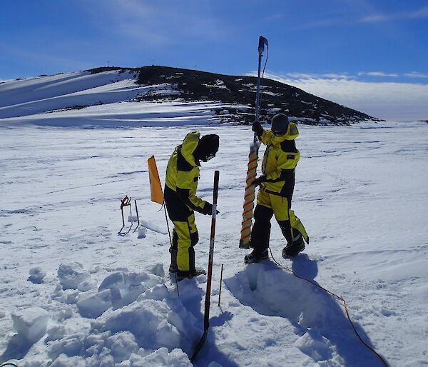 Scientists prepare to extract a fast-ice core to characterize sea-ice properties, including ice-crystal structure, salinity, density or chlorophyll content.