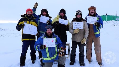 Group of expeditioners in snow with messages for Mother’s Day