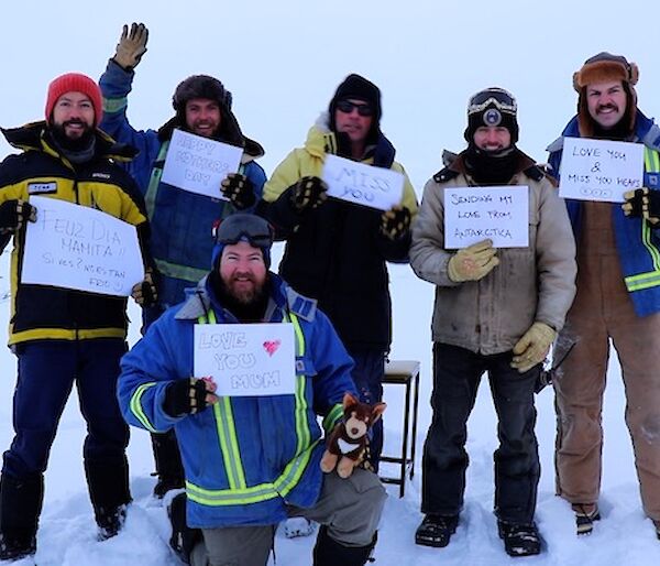 Group of expeditioners in snow with messages for Mother’s Day