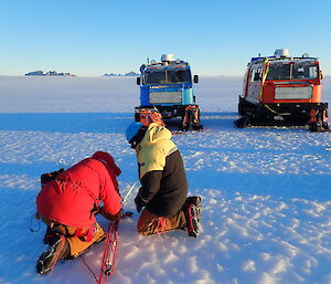 expeditioners and vehicles in snow