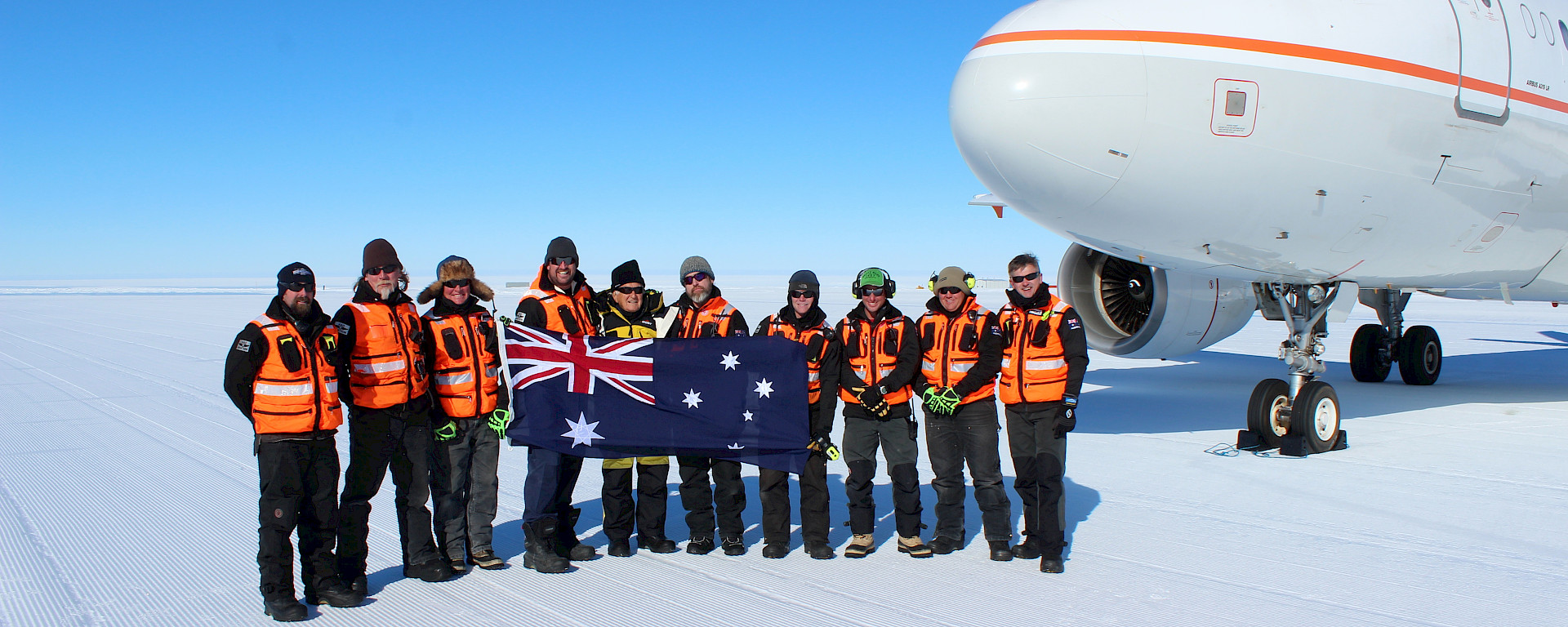 Former Australian Prime Minister Bob Hawke with Australian expeditioners in front of an Airbus A319 on an ice runway.