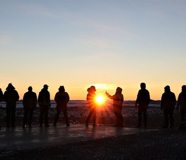 Expeditioners silhouetted against sunset