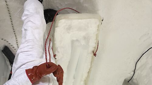 Scientist inside trench with ice drill