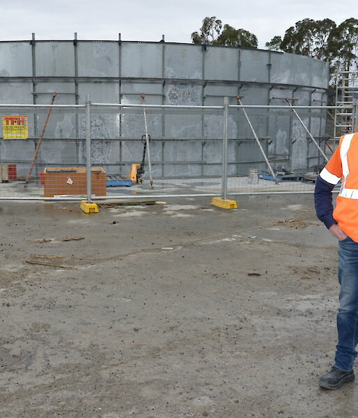 Man wearing high vis in front of partially constructed water tank