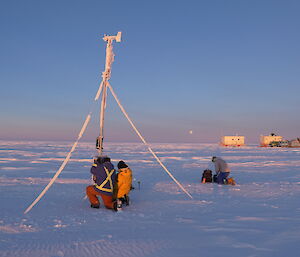 group of people in snowscape with automatic weather station