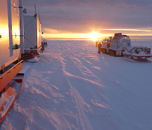 sunset with vehicles over ice