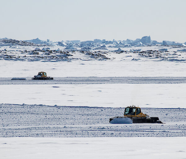 Two groomers preparing the sea-ice ski landing area in front Davis research station