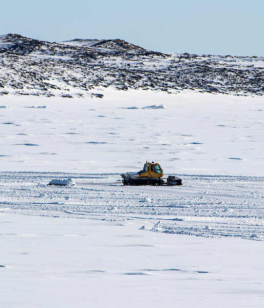 A drag beam is towed behind a snow groomer to flatten and distribute the snow over the landing area