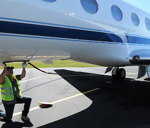 A man fits the cover on a laser altimeter on the bottom of the plane