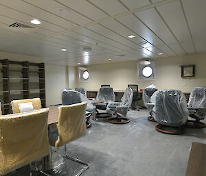 The library on the ship with empty bookshelves and seating.