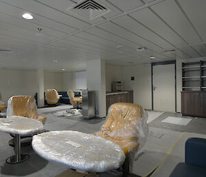 A lounge area on the ship with leather seats and small tables.