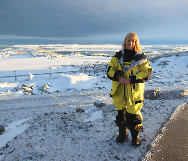 Women in yellow standing in white snow.