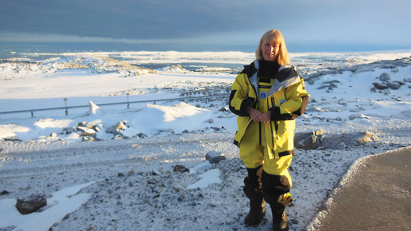 Women in yellow standing in white snow.