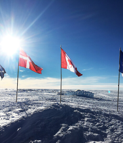 International flags of the participating nations fly over the Mount Brown ice core drill site