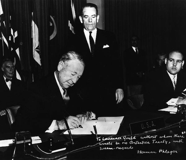 United States representative, Herman Phleger, sits at a desk to sign the Antarctic Treaty in December 1959.