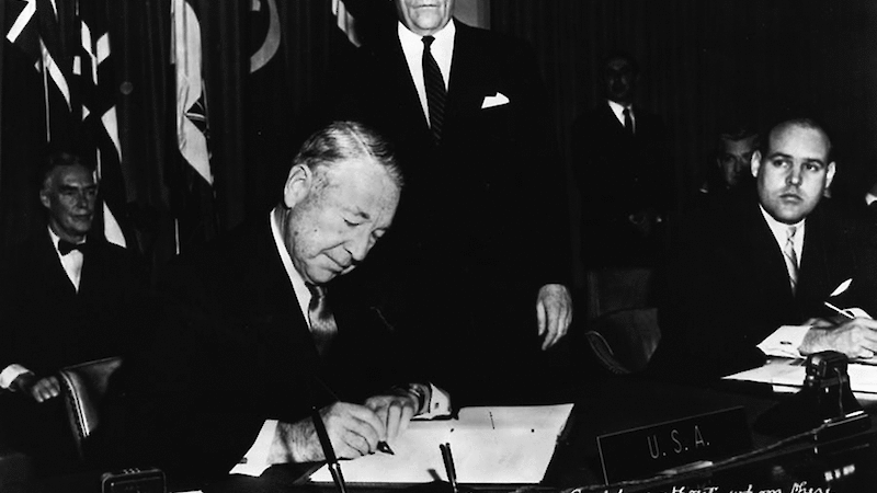 United States representative, Herman Phleger, sits at a desk to sign the Antarctic Treaty in December 1959.