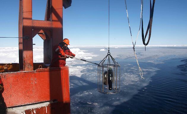 Scientist deploying equipment off RSV Aurora Australis in the Southern Ocean