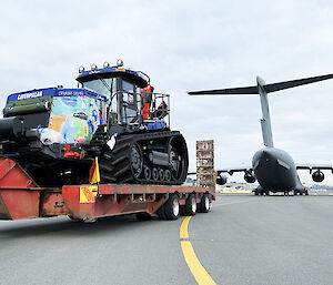 Tractor on trailer behind plane