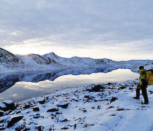 Expeditioner standing on the edge of a lake