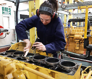 Female antarctic expedition mechanic working on an engine