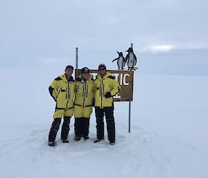 In a Chippie Sandwich – me with two of our winter carpenters at the Antarctic Circle sign: Conrad Willersdorf and Aaron Coleman