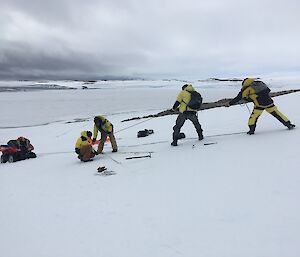Four expeditioners praticing quad recovery on the Mitchell Peninsula