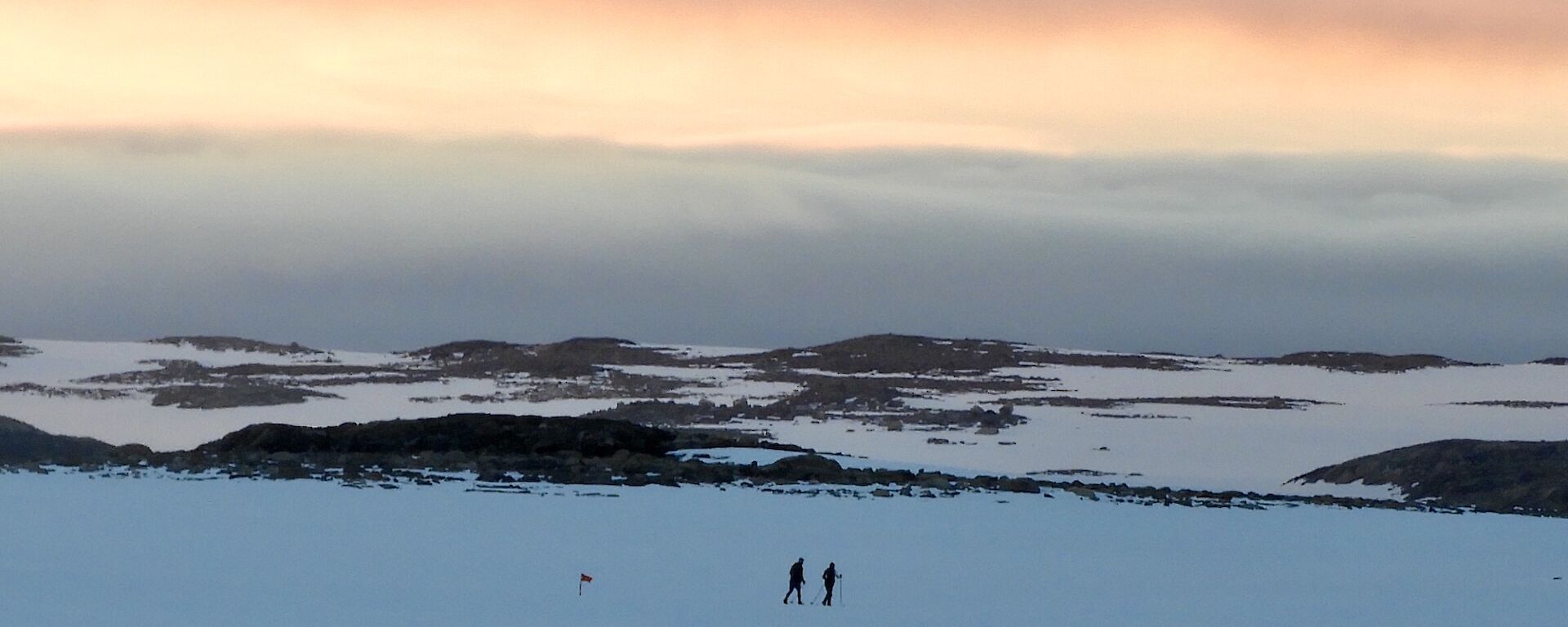 Casey sunrise with two expeditioners out for a morning ski in the recreation area