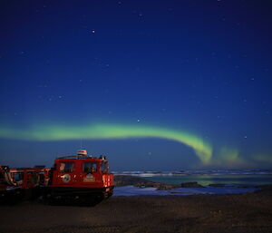 A green Aurora Australis over the bay with the Red Hagg in the foreground