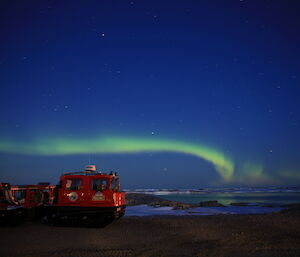 A green Aurora Australis over the bay with the Red Hagg in the foreground
