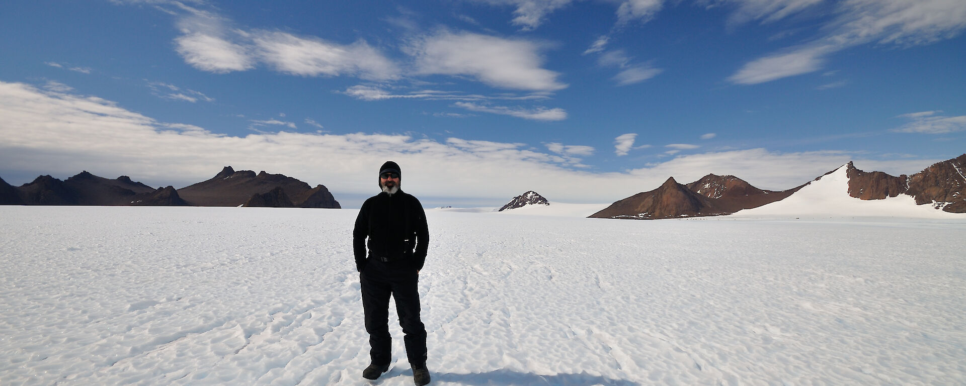 Simon standing on the snow with rocks in the background