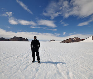 Simon standing on the snow with rocks in the background