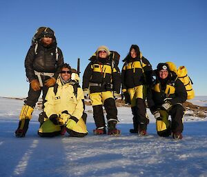 The five members of the Ferrari field team standing on snow together