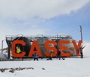 Expeditioners spelling out Casey in front of the Casey sign