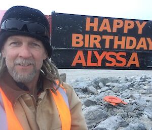 Rhys infront of a Happy birthday sign for his niece Alyssa