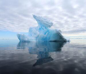 A blue iceberg reflected into the water