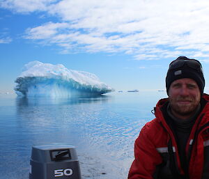 Scott driving the boat with an iceberg in the background