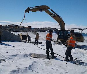 Rolling out the HV cable using a large crane and team members to lay it across the snow